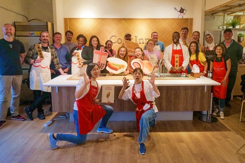 A group of British social media influencers pose for a photo after participating in a cooking class at CookInn Taiwan.